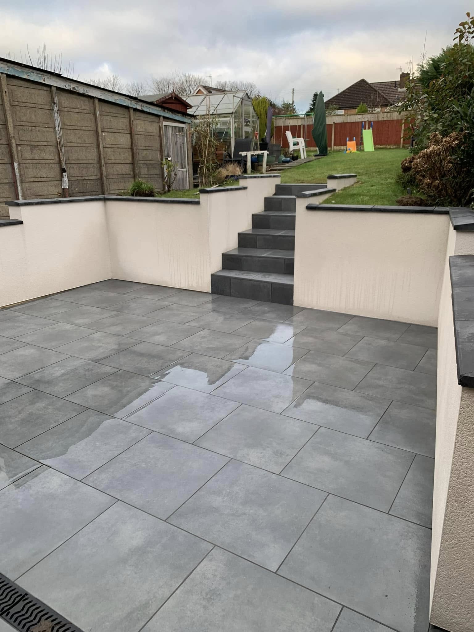 Grey patio with steps to garden