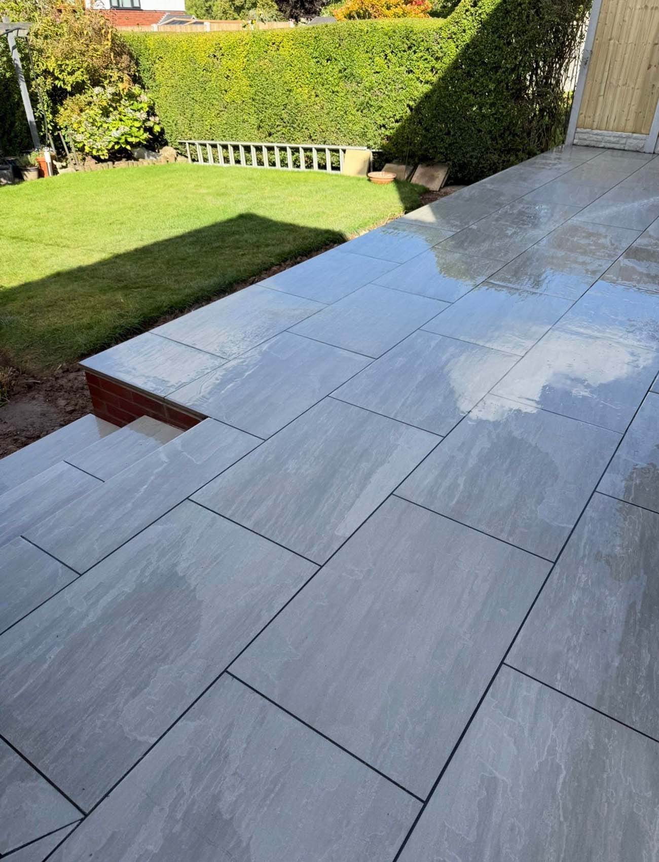 Grey patio with steps to garden
